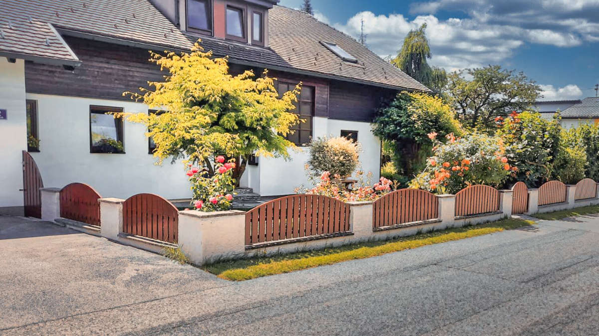 Brauner Aluminium Gartenzaun vor einem Einfamilienhaus